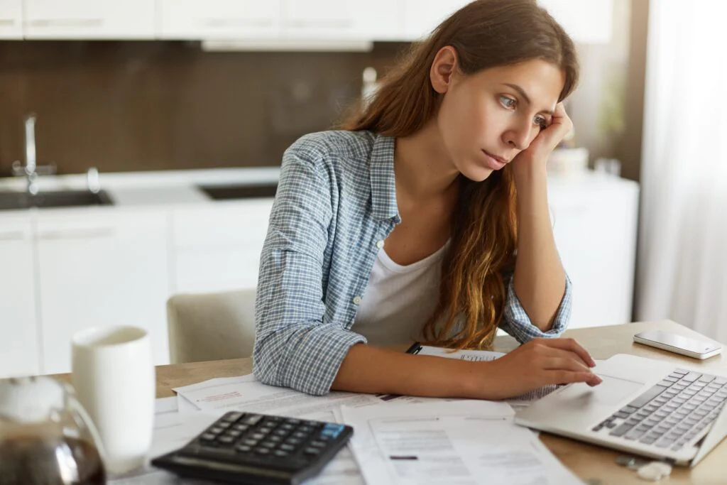 blog 4b27f674f54a young woman checking her budget doing taxes min