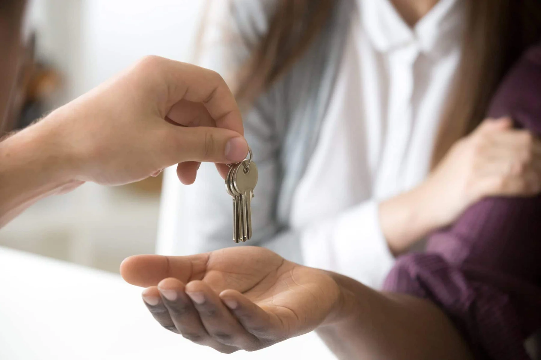 blog 7898c369f603 realtor giving african customer keys couple buying house closeup min